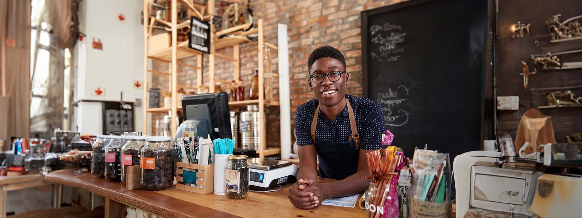 Hombre con delantal atrás del mostrador de una tienda