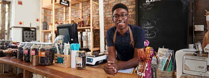 Hombre con delantal atrás del mostrador de una tienda