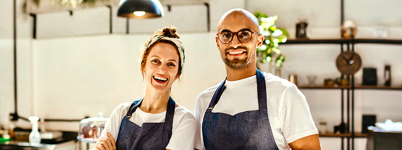 Hombre y Mujer con delantales en la cocina