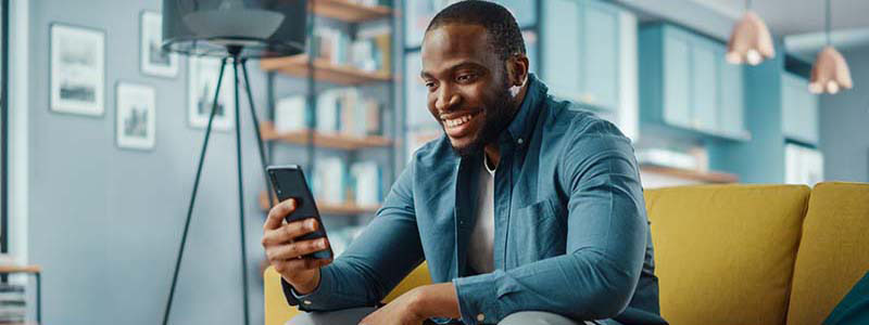 Hombre sonriendo mirando su teléfonos 