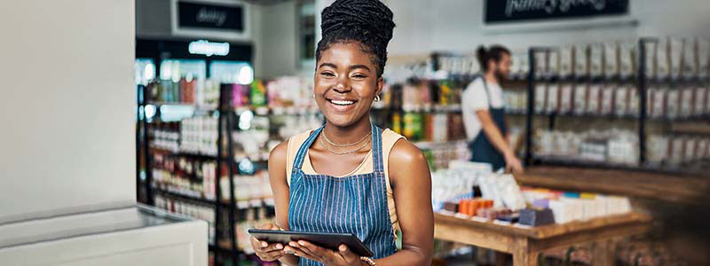 Mujer sonriente usando una tablet mientras trabaja