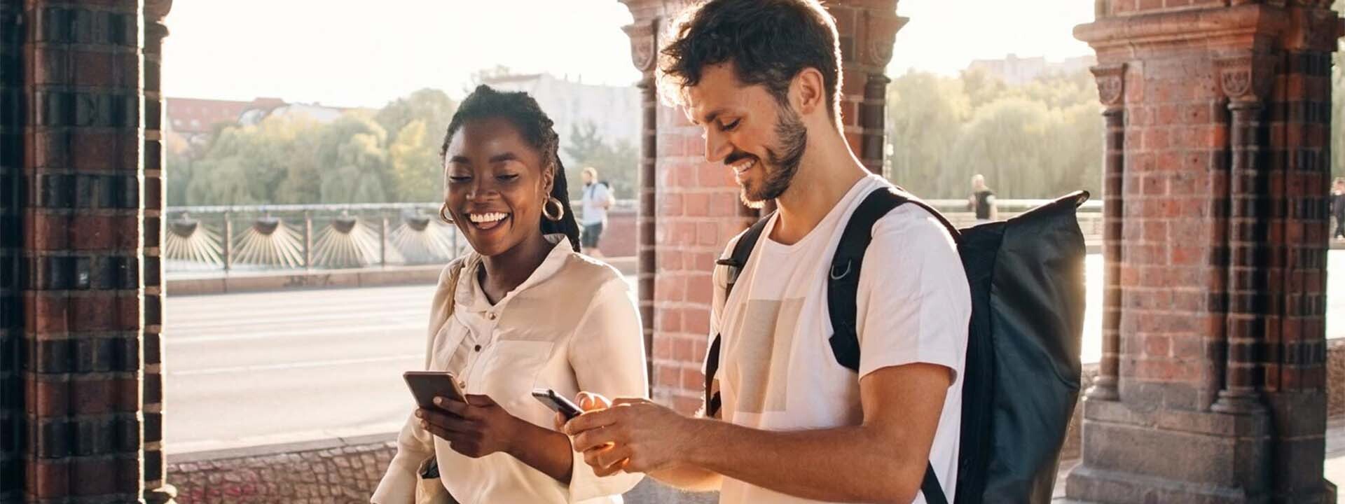 Hombre y mujer hablando mientras utilizan su teléfono