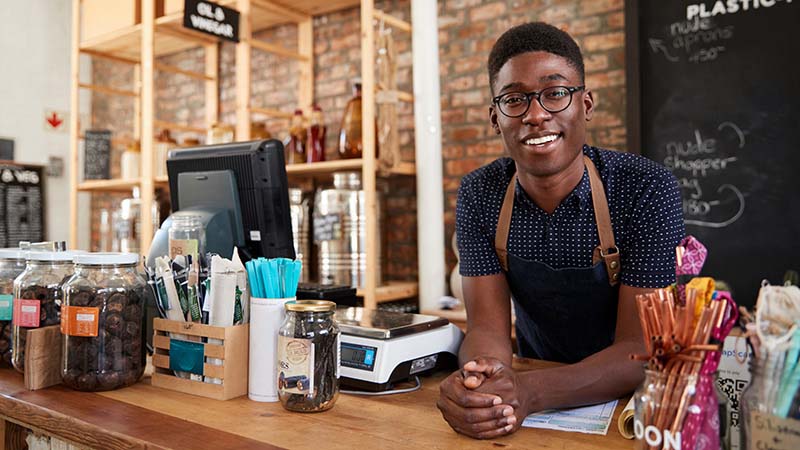 Hombre con delantal atrás del mostrador de una tienda