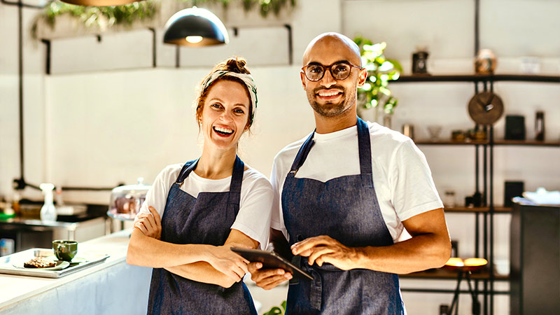Hombre y Mujer con delantales en la cocina